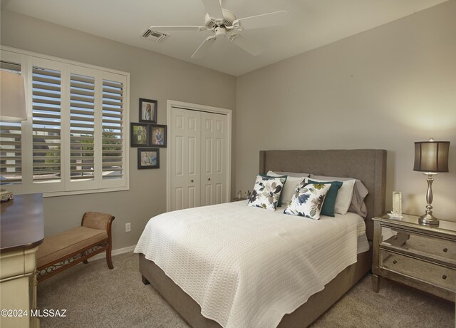 bedroom with ceiling fan, a closet, and light carpet