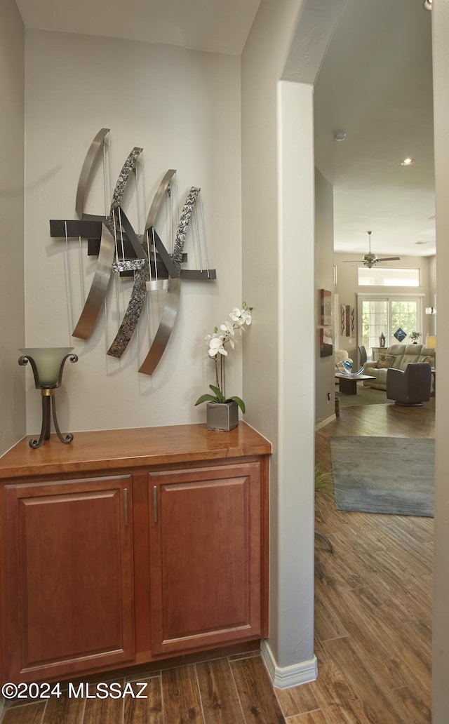 interior details with baseboards, wood finished floors, and a ceiling fan