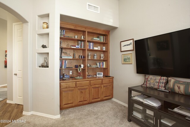 bar featuring built in shelves and light colored carpet