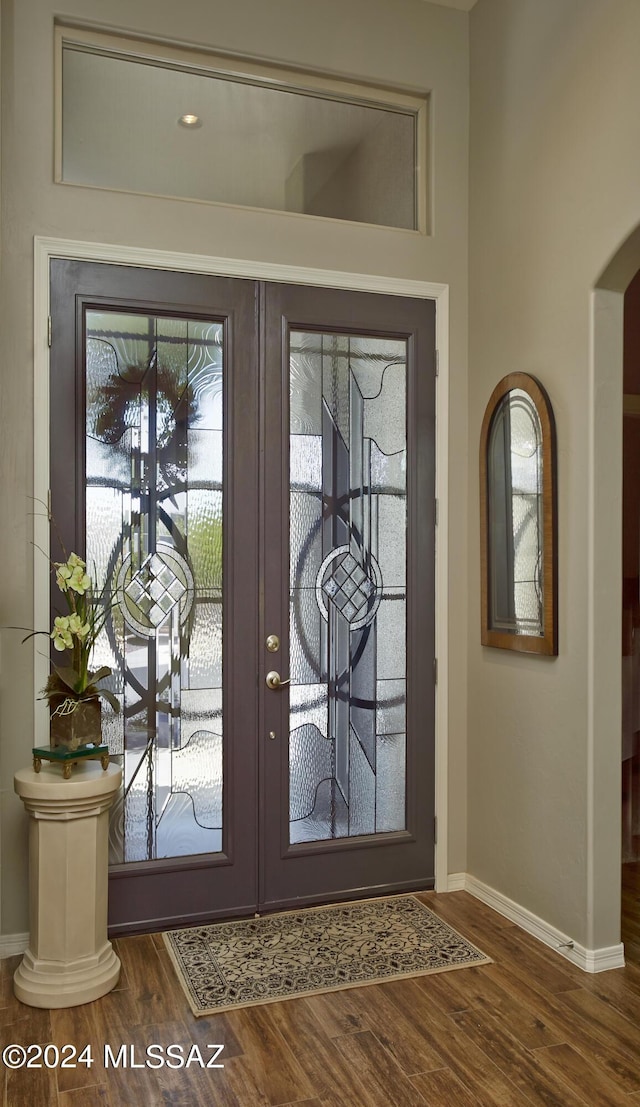 foyer entrance with french doors, a healthy amount of sunlight, and dark hardwood / wood-style floors