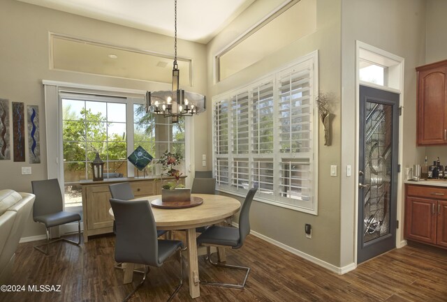 dining room with dark hardwood / wood-style flooring and a notable chandelier