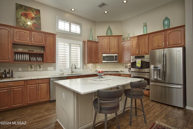 kitchen featuring dark hardwood / wood-style flooring, a center island, stainless steel appliances, and sink