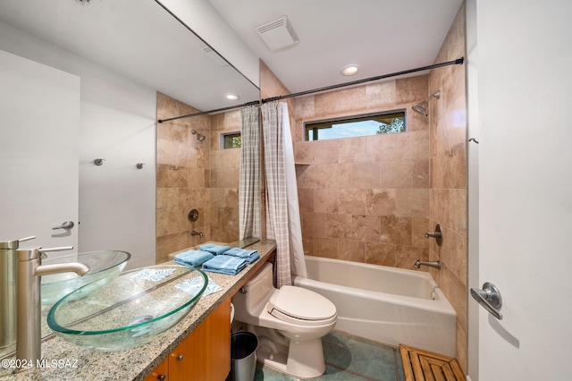 full bathroom with shower / tub combo with curtain, vanity, and toilet