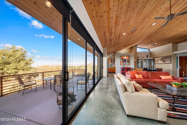 unfurnished living room with wood ceiling, vaulted ceiling, a healthy amount of sunlight, concrete flooring, and ceiling fan