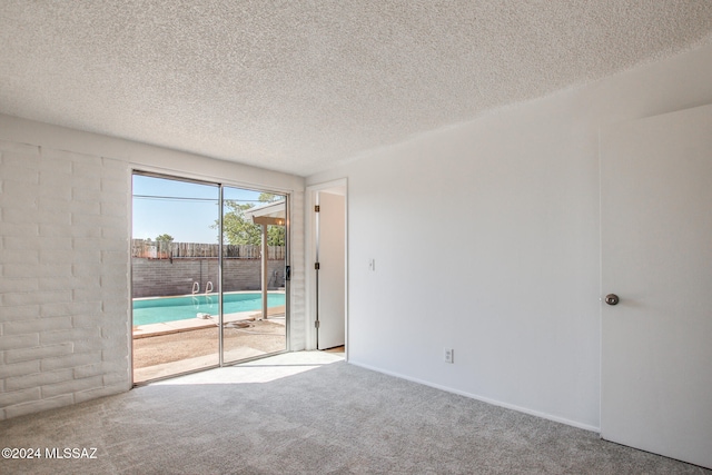 spare room with a textured ceiling and light colored carpet