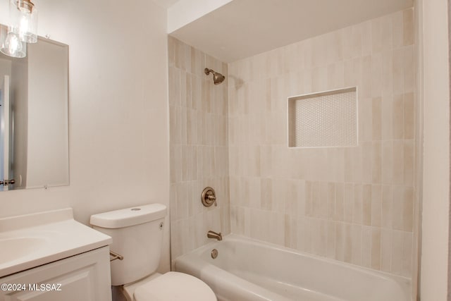 full bathroom featuring vanity, tiled shower / bath combo, and toilet