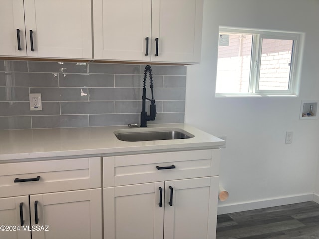 kitchen with white cabinets, decorative backsplash, dark hardwood / wood-style flooring, and sink