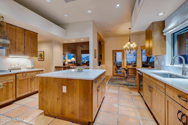 kitchen with a center island, decorative light fixtures, sink, decorative backsplash, and stainless steel dishwasher