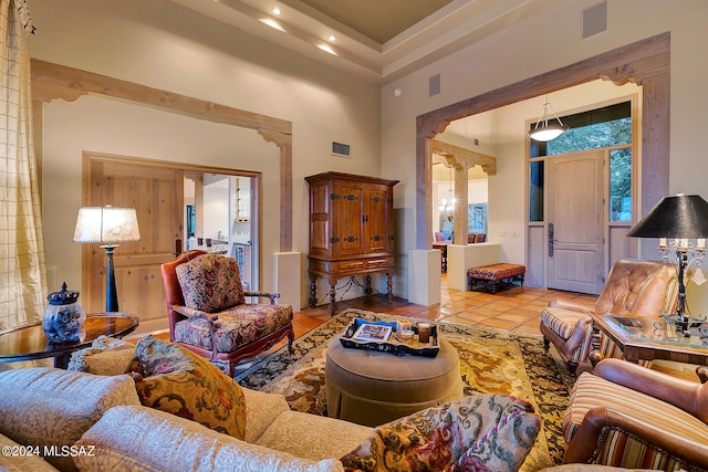 tiled living room with ornate columns and a towering ceiling