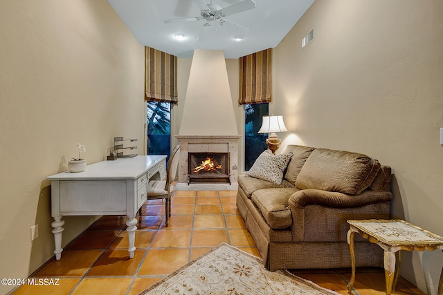 living area with a fireplace, light tile patterned floors, and ceiling fan