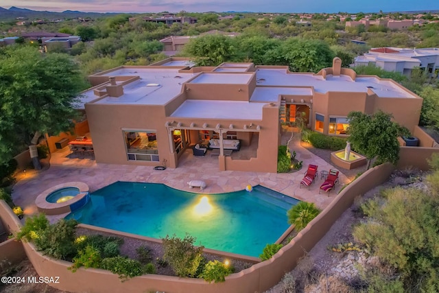 pool at dusk with a patio area