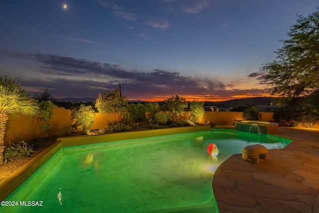 pool at dusk featuring a patio area