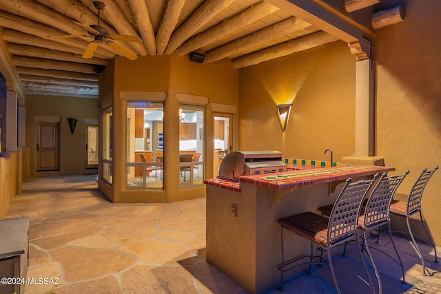 view of patio / terrace featuring ceiling fan and exterior bar