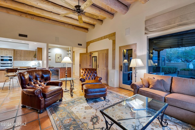 tiled living room featuring ceiling fan, beam ceiling, beverage cooler, and a towering ceiling