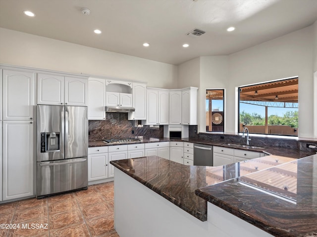 kitchen with kitchen peninsula, sink, white cabinets, and appliances with stainless steel finishes