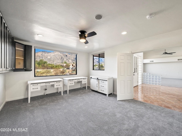 home theater room featuring ceiling fan and dark carpet