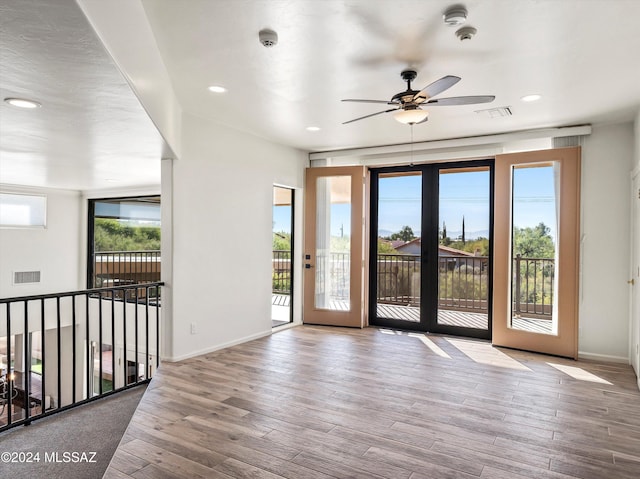 empty room with light wood-type flooring, a wealth of natural light, and ceiling fan