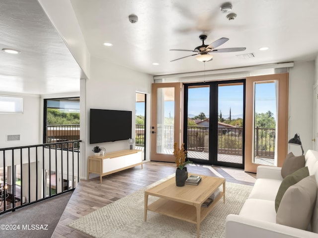 living room featuring ceiling fan, light hardwood / wood-style flooring, and a healthy amount of sunlight