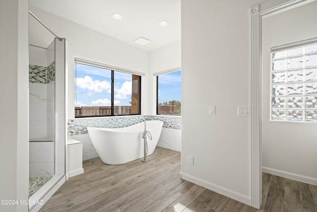 bathroom featuring separate shower and tub and wood-type flooring