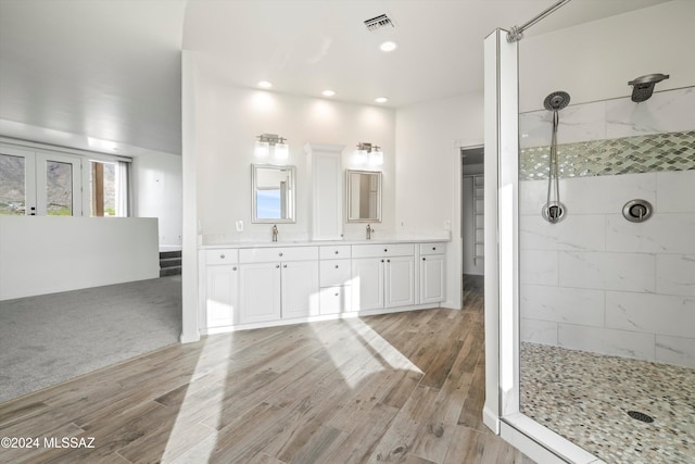 bathroom with tiled shower, french doors, vanity, and hardwood / wood-style flooring