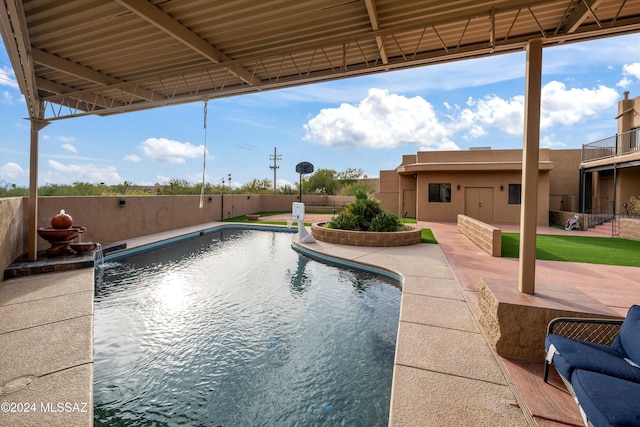 view of swimming pool featuring pool water feature and a patio area