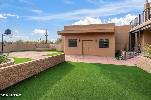 back of house with a lawn and a patio