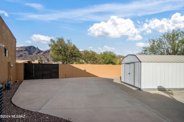 view of patio with a mountain view and a shed