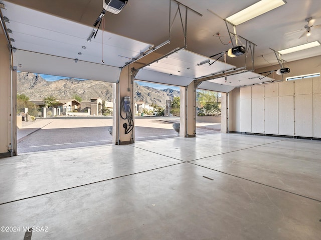 garage featuring a mountain view, a garage door opener, and ceiling fan