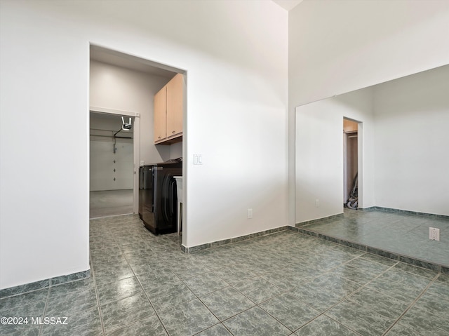 unfurnished living room featuring dark tile patterned flooring and separate washer and dryer