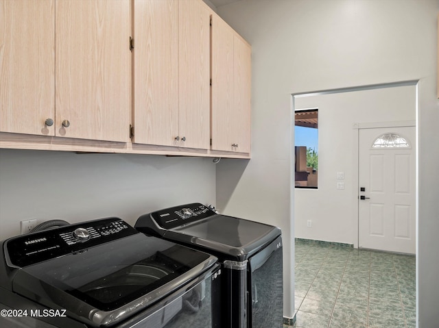 laundry area with washer and clothes dryer, light tile patterned flooring, and cabinets