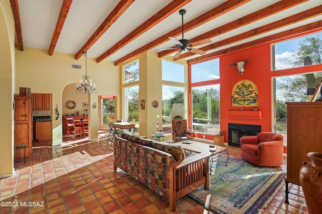 living room featuring ceiling fan with notable chandelier, tile patterned flooring, a towering ceiling, and beamed ceiling