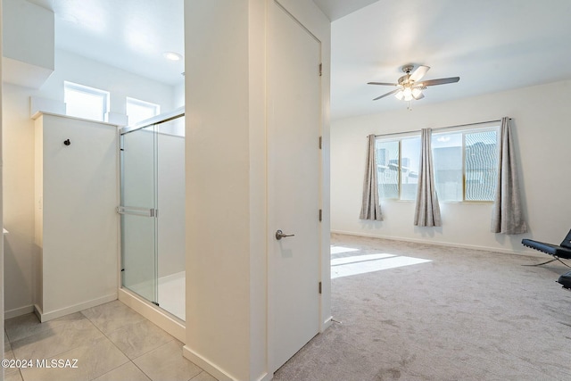 bathroom featuring tile patterned flooring, ceiling fan, and an enclosed shower