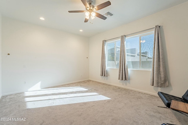 carpeted spare room with ceiling fan