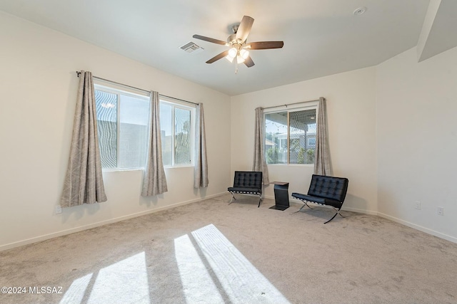 sitting room featuring light colored carpet and ceiling fan