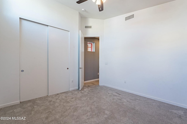 unfurnished bedroom featuring ceiling fan, a closet, and light carpet