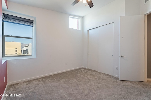 unfurnished bedroom with light carpet, a closet, and ceiling fan