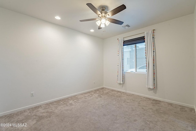 spare room featuring light carpet and ceiling fan