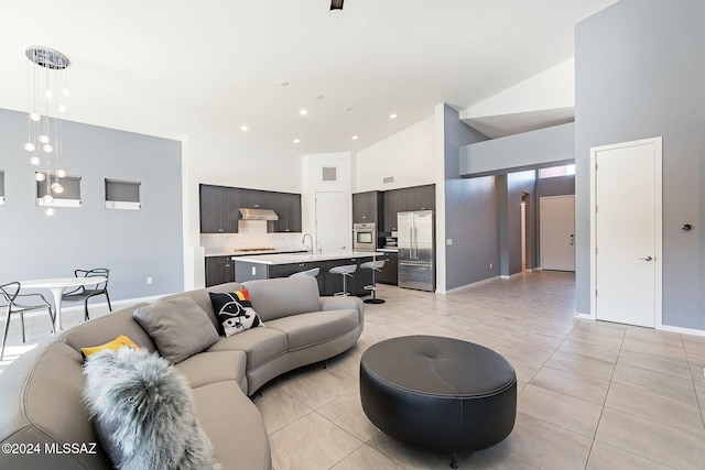 tiled living room featuring sink and high vaulted ceiling