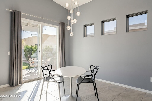 dining space featuring vaulted ceiling and tile patterned floors