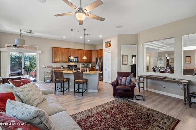 living room featuring ceiling fan and light hardwood / wood-style floors