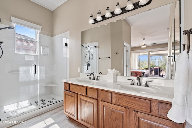 bathroom with wood-type flooring, vanity, a shower with shower door, and ceiling fan