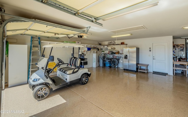 garage with stainless steel fridge with ice dispenser and a garage door opener