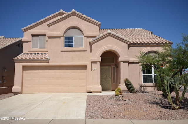 mediterranean / spanish-style home with a garage