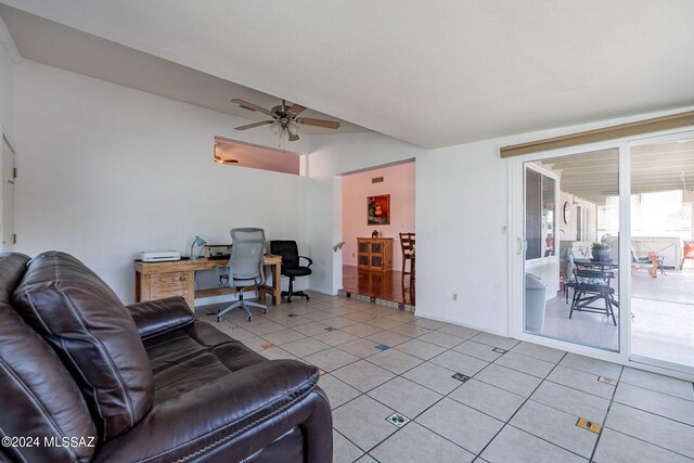 kitchen featuring stainless steel appliances, a sink, light stone counters, and a ceiling fan