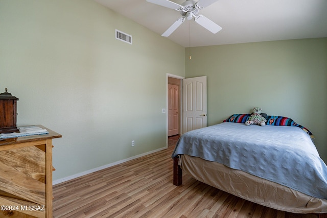 bedroom with ceiling fan, lofted ceiling, light wood-style flooring, visible vents, and baseboards