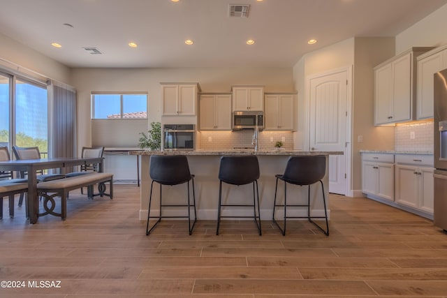 kitchen with white cabinetry, visible vents, stainless steel appliances, light wood-type flooring, and recessed lighting