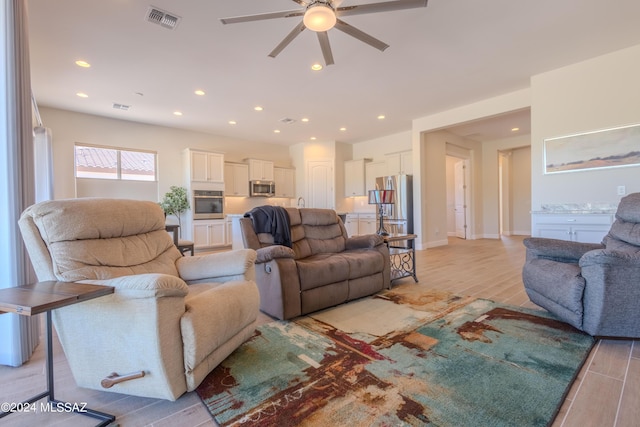 living area featuring visible vents, a ceiling fan, recessed lighting, and light wood-style floors