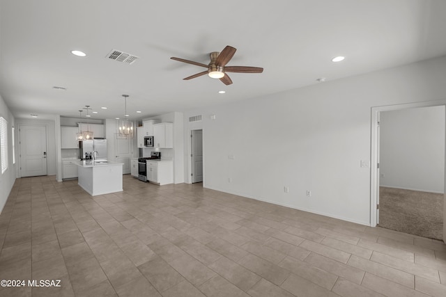 unfurnished living room featuring visible vents, baseboards, recessed lighting, a sink, and ceiling fan with notable chandelier