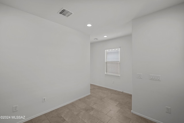 spare room featuring baseboards, visible vents, and recessed lighting