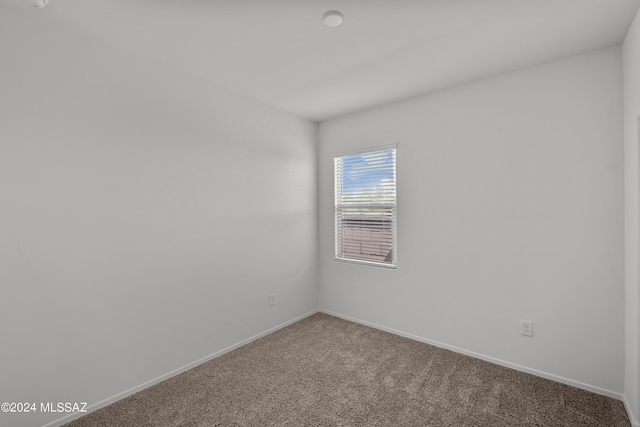 unfurnished room featuring carpet flooring and baseboards